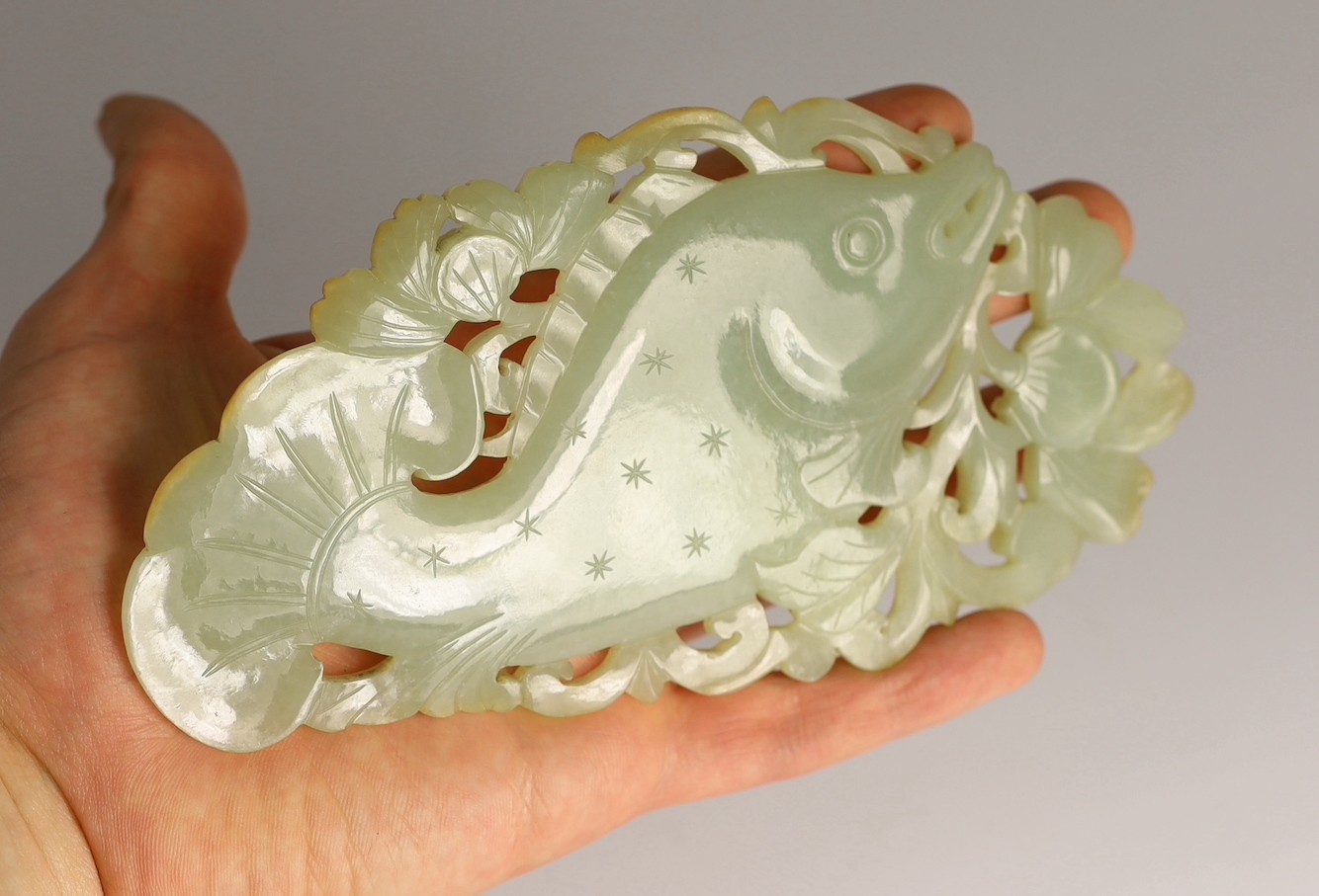 A Chinese pale celadon jade 'fish' plaque, 18th/19th century, 16.7cm long, 8.5cm high, later wood stand for use as a table screen